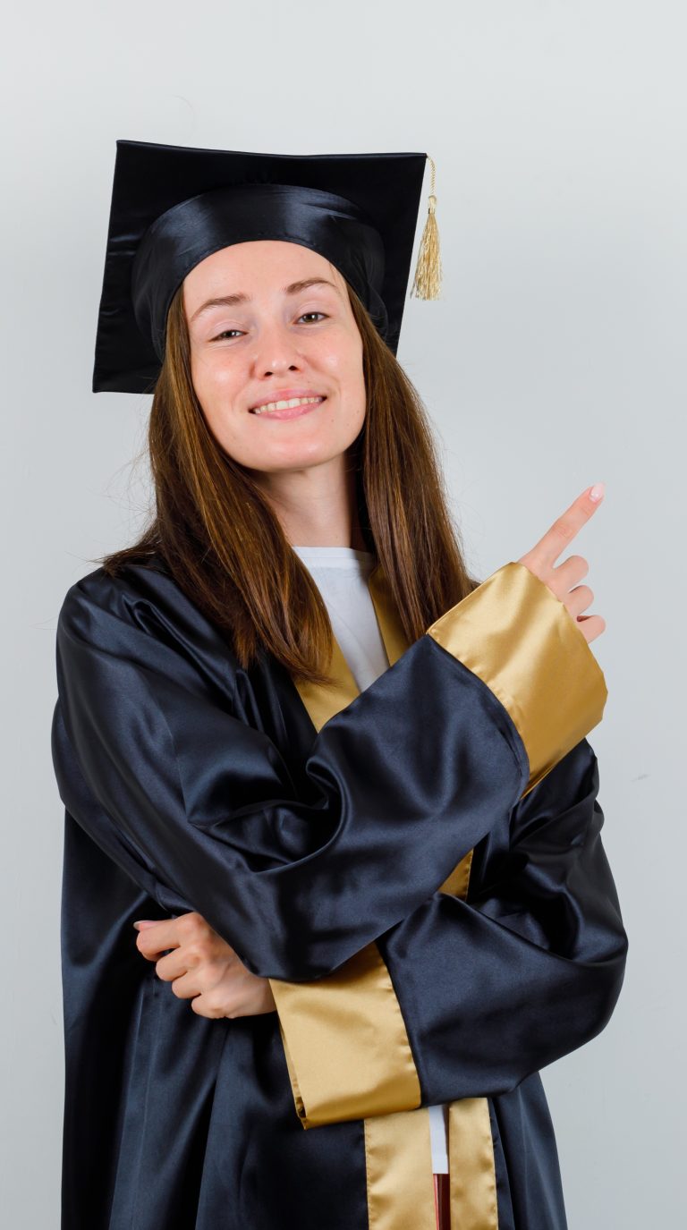 young-female-graduate-pointing-upper-right-corner-academic-dress-looking-confident-front-view-768x1375